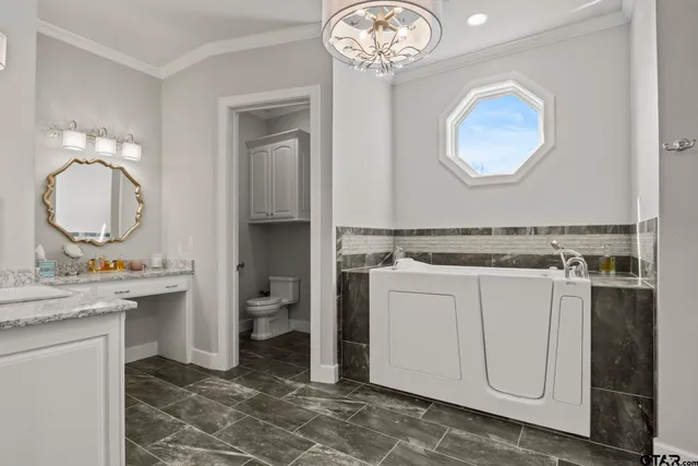 a room with a chandelier a sink and a mirror