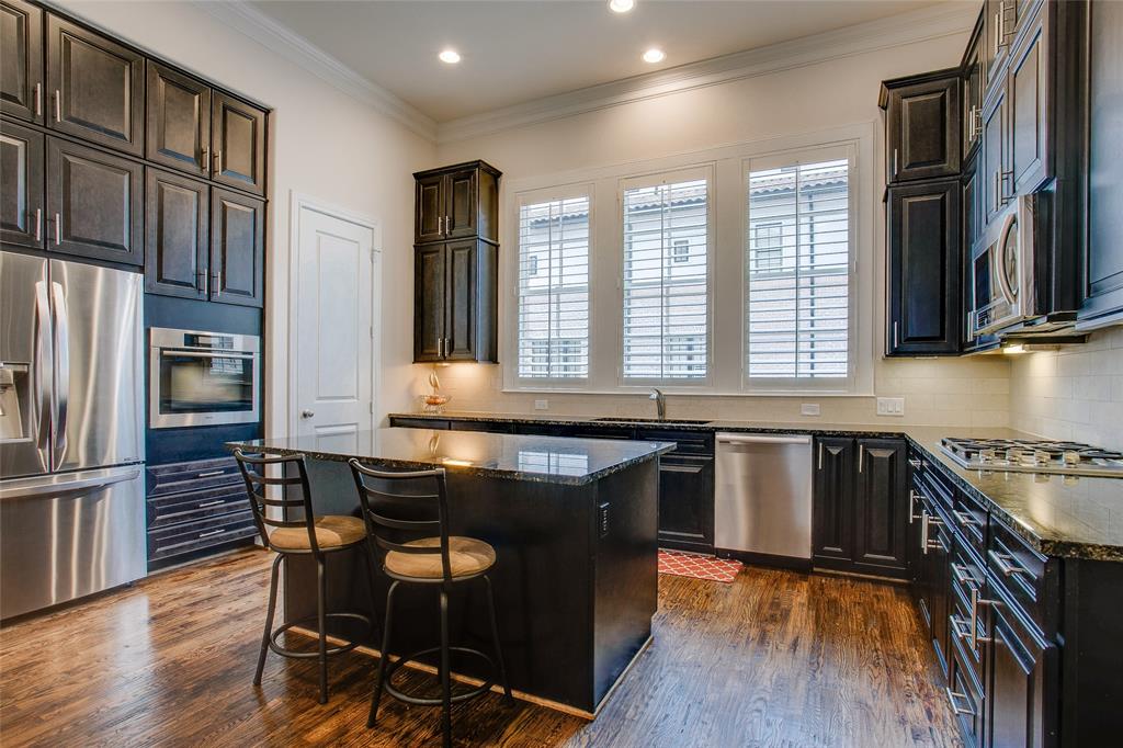 a kitchen with kitchen island granite countertop wooden floors and stainless steel appliances