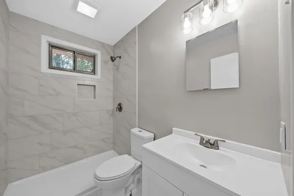 a bathroom with a toilet a sink and mirror