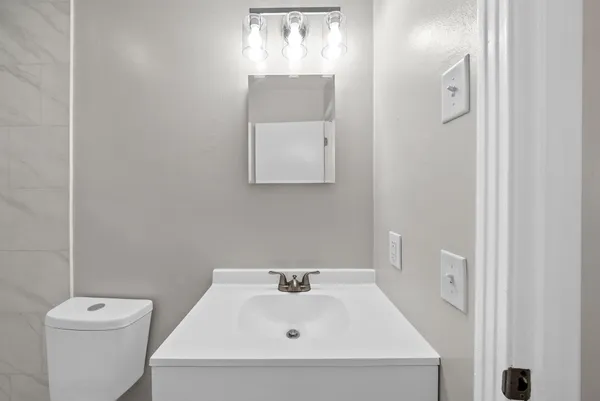 a bathroom with a sink and mirror with toilet