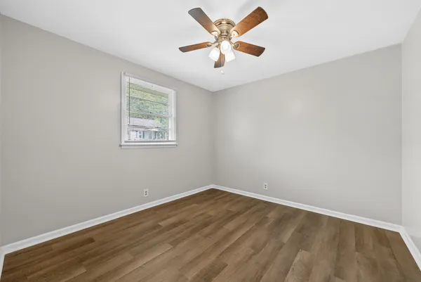 an empty room with a window and a fan