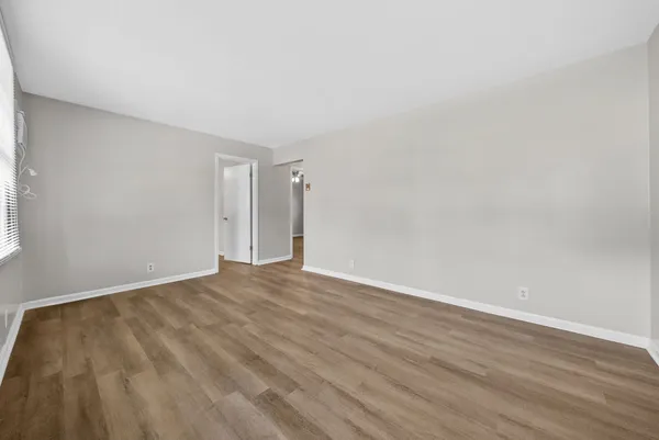 a view of an empty room with wooden floor
