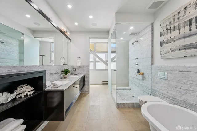 a bathroom with a double vanity sink a toilet and bathtub