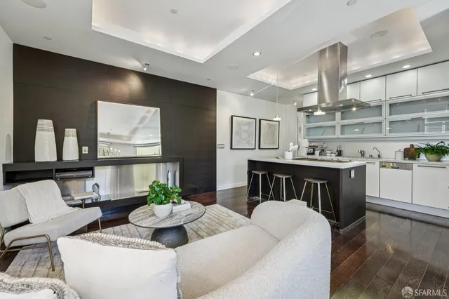 a living room with furniture kitchen view and a large window