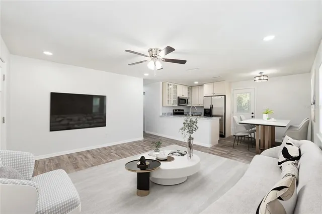 a living room with furniture kitchen view and a flat screen tv
