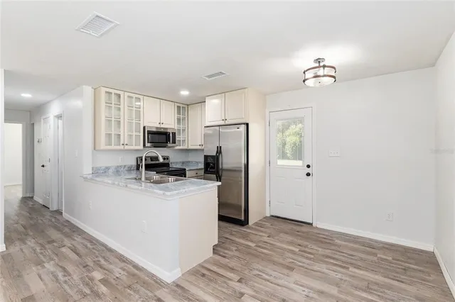 a kitchen with refrigerator cabinets and wooden floor