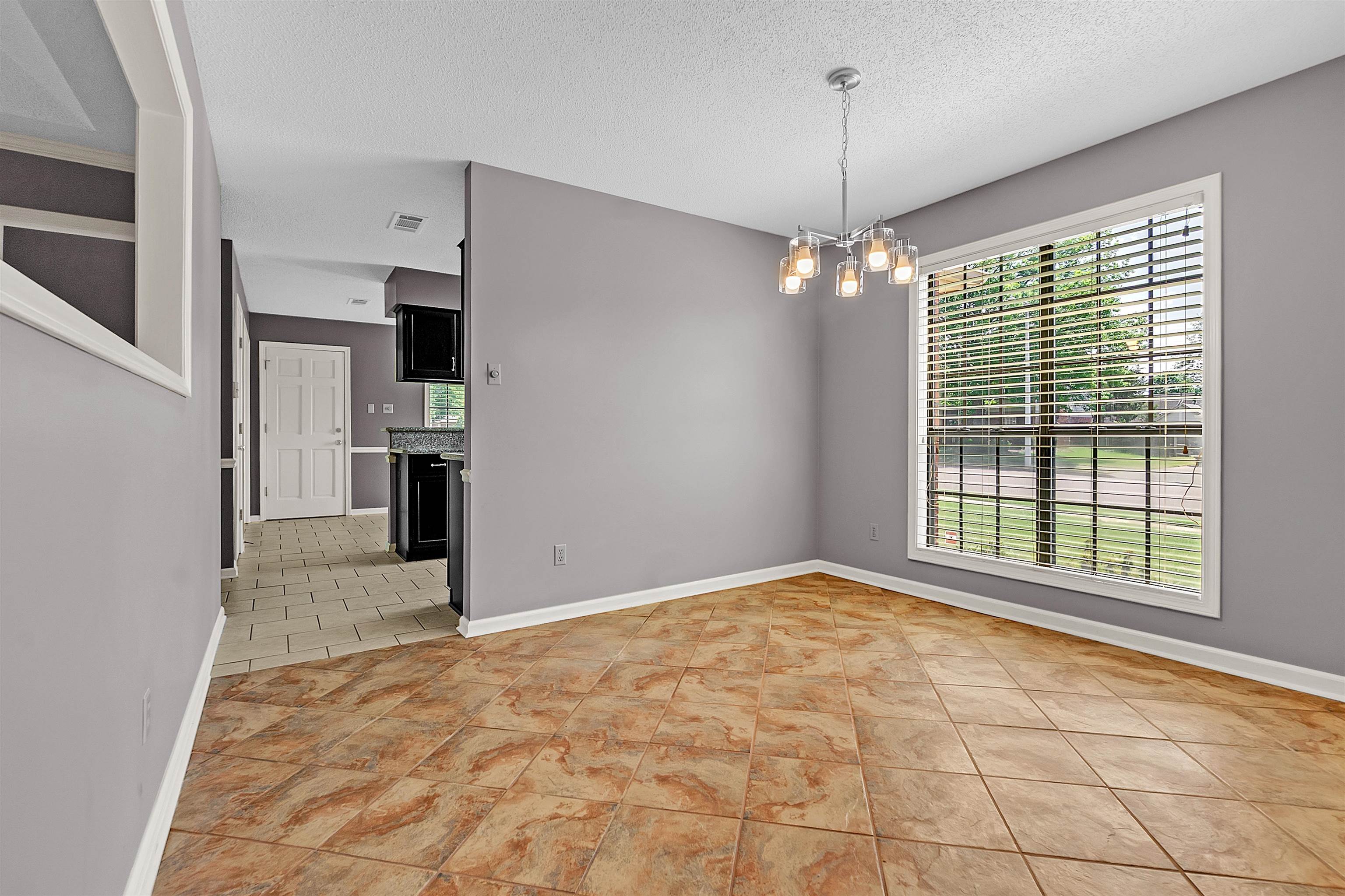 6512 Birch Mill Road Bartlett, TN 38135 - Photo 12 of 25 Unfurnished room featuring a chandelier, a textured ceiling, and light tile patterned flooring