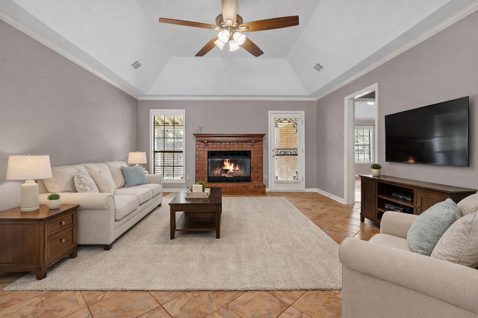 6512 Birch Mill Road Bartlett, TN 38135 - Photo 4 of 25 Living area with crown molding, a fireplace, a ceiling fan, healthy amount of natural light, and light tile patterned floors