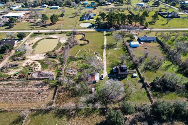 an aerial view of a tennis ground and a large tree
