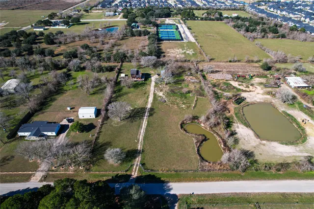 an aerial view of a house with a yard and lake view in back