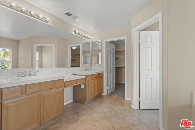 a large bathroom with a granite countertop sink mirror and cabinets