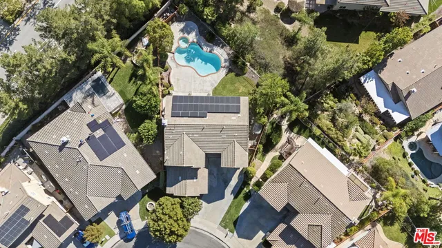 an aerial view of a house with a swimming pool and outdoor seating