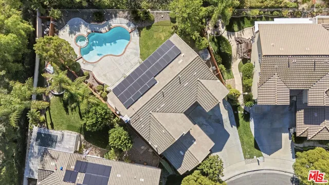 a view of a white house with a large window and potted plants