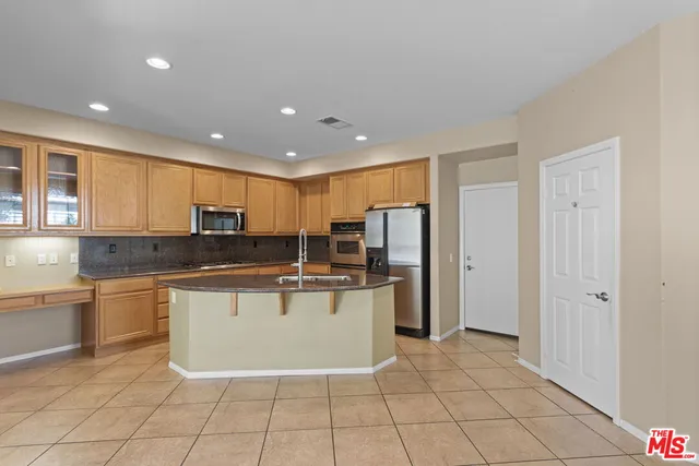a kitchen with stainless steel appliances a refrigerator sink and cabinets