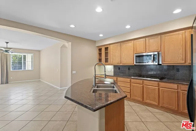 a kitchen with stainless steel appliances granite countertop a sink stove and cabinets