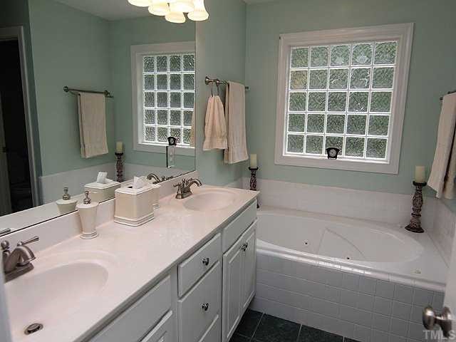 6820 Cool Pond Road Raleigh, NC 27613 - Photo 7 of 12 a bathroom with a tub sink and a mirror