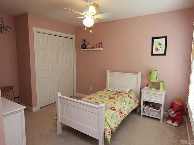 6820 Cool Pond Road Raleigh, NC 27613 - Photo 9 of 12 a bedroom with a bed and a chandelier