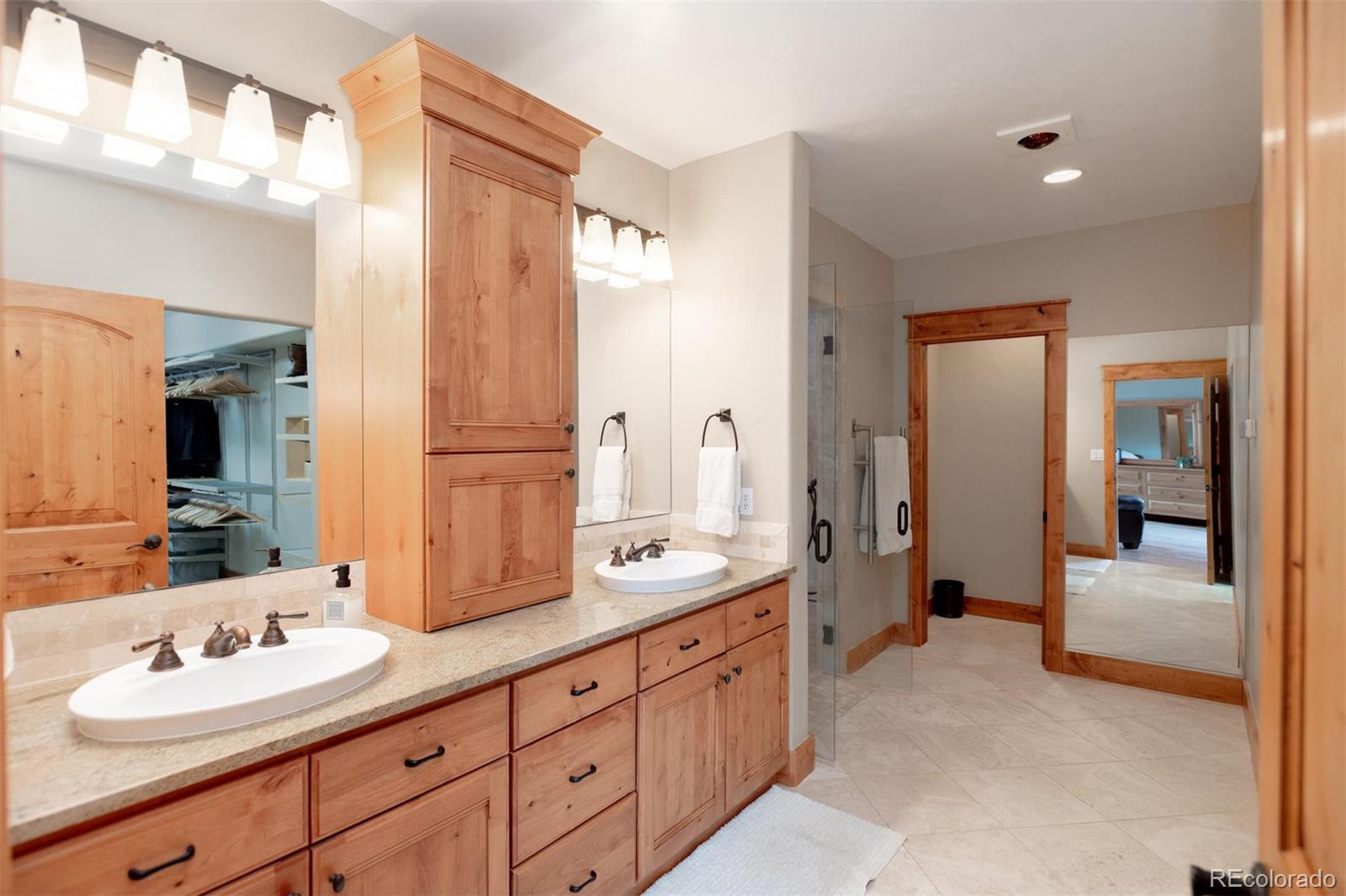 33231 Meadow Mountain Road Evergreen, CO 80439 - Photo 18 of 40 a spacious bathroom with a double vanity sink shower and mirror