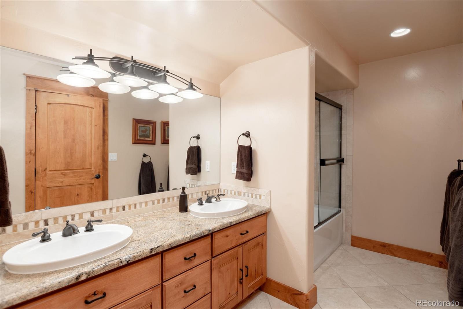 33231 Meadow Mountain Road Evergreen, CO 80439 - Photo 25 of 40 a bathroom with a double vanity sink and mirror