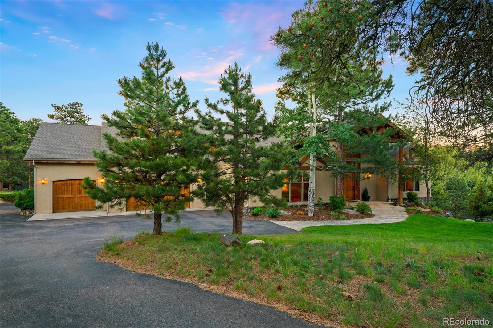 33231 Meadow Mountain Road Evergreen, CO 80439 - Photo 38 of 40 a front view of a house with garden and trees
