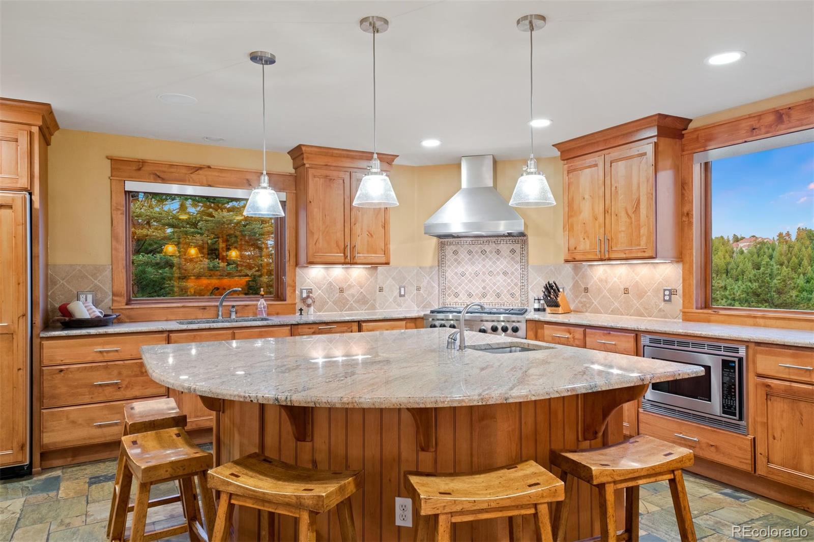 33231 Meadow Mountain Road Evergreen, CO 80439 - Photo 5 of 40 a kitchen with a table chairs stove and wooden floor
