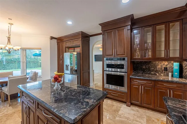 a kitchen with stainless steel appliances granite countertop a stove a sink and a refrigerator