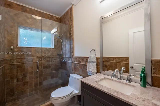 a bathroom with a granite countertop sink toilet a mirror and shower