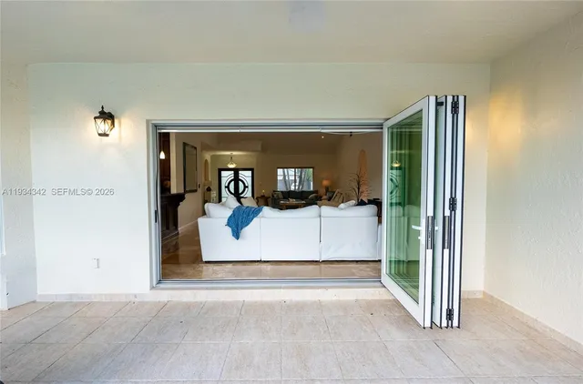 a view of a hallway with wooden floor and a living room