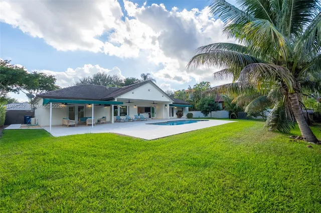 a front view of a house with swimming pool having outdoor seating