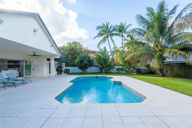 a view of swimming pool with outdoor seating and a garden