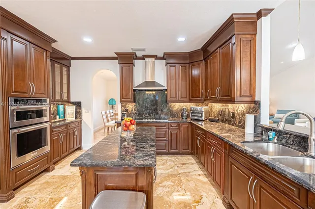 a kitchen with stainless steel appliances granite countertop a sink stove and cabinets