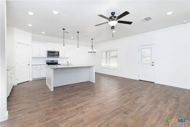 an open kitchen with kitchen island white cabinets and refrigerator