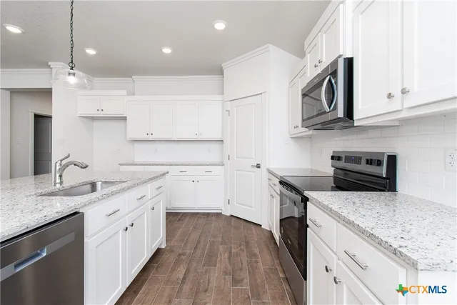 a kitchen with stainless steel appliances granite countertop a sink stove and cabinets