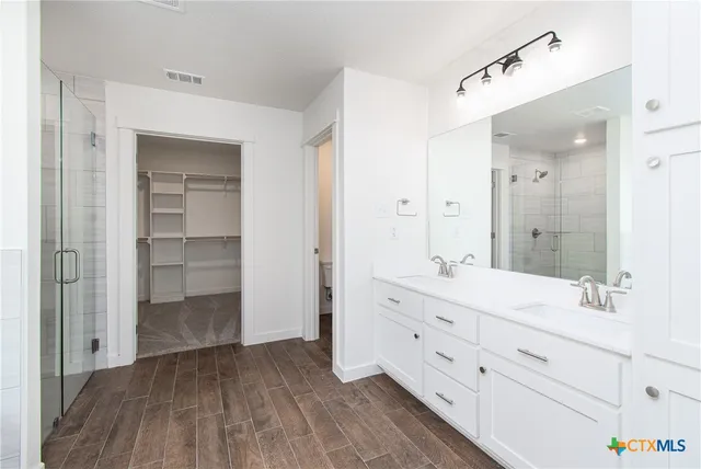 a bathroom with a double vanity sink and mirror