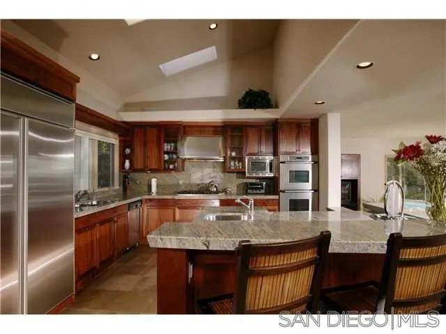 980 Crest Road Del Mar, CA 92014 - Photo 4 of 13 a kitchen with stainless steel appliances granite countertop a sink refrigerator and cabinets