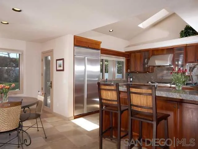980 Crest Road Del Mar, CA 92014 - Photo 5 of 13 a kitchen with granite countertop a table chairs microwave and cabinets