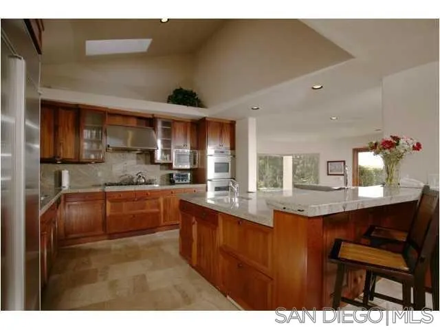 980 Crest Road Del Mar, CA 92014 - Photo 6 of 13 a kitchen with stainless steel appliances granite countertop a sink and cabinets