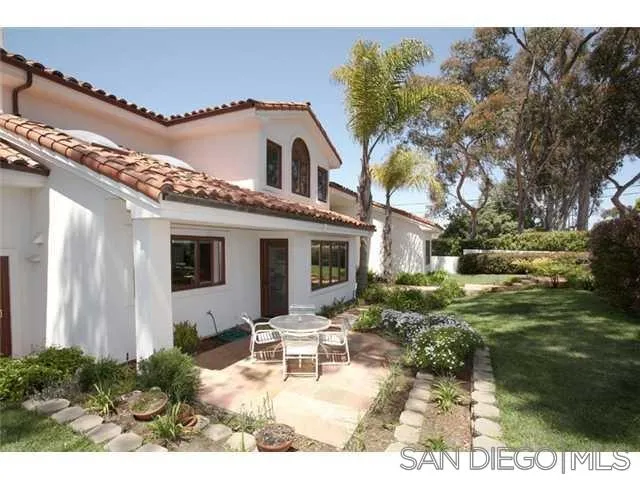 980 Crest Road Del Mar, CA 92014 - Photo 9 of 13 a view of a white house with a big yard and potted plants