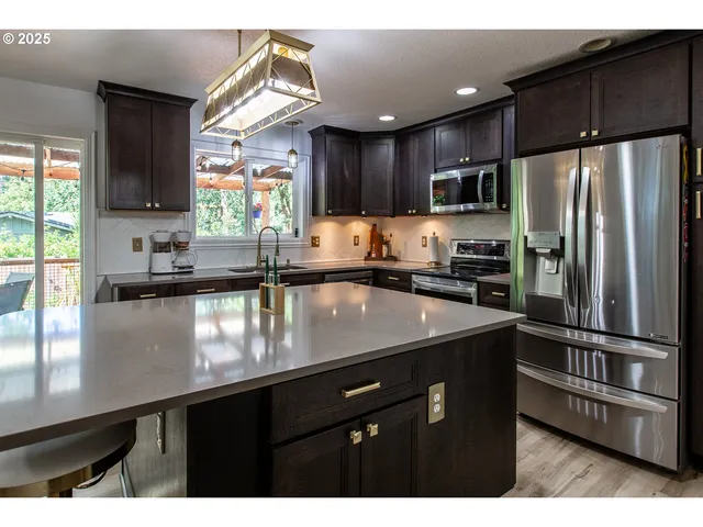 a kitchen with kitchen island granite countertop a sink window and refrigerator