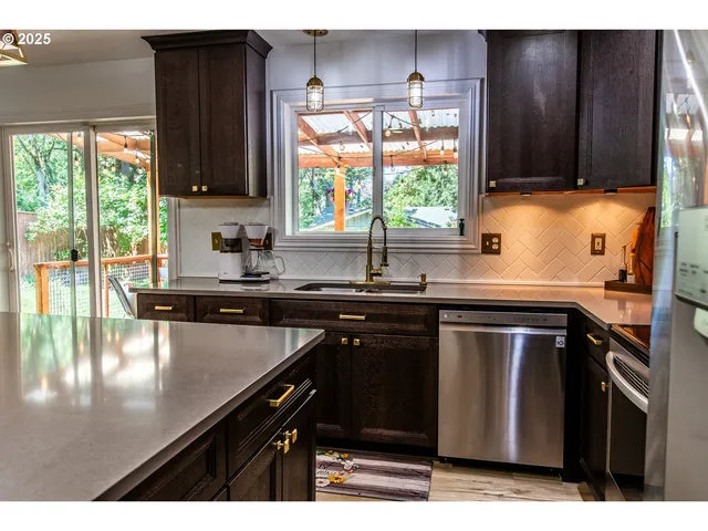 a kitchen with kitchen island granite countertop a sink cabinets and window