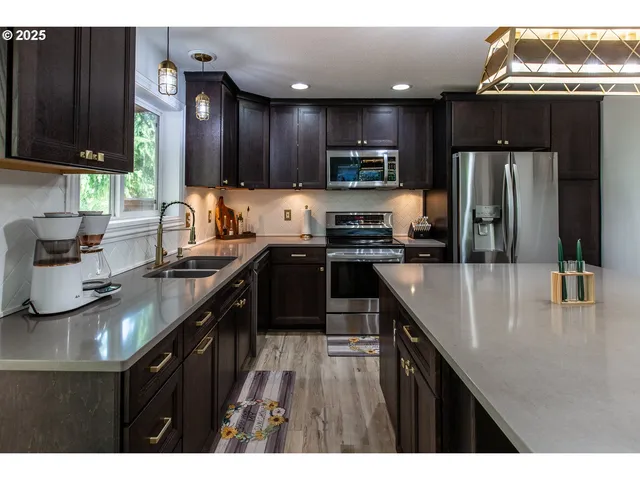 a kitchen with kitchen island granite countertop a sink counter top space appliances and cabinets