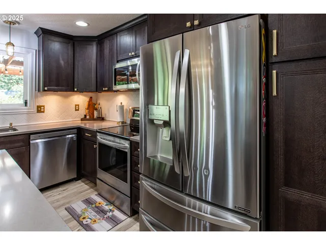 a kitchen with stainless steel appliances granite countertop a refrigerator and a sink