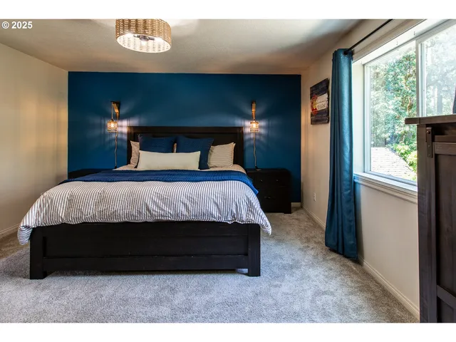 a bed sitting in a bedroom next to a window