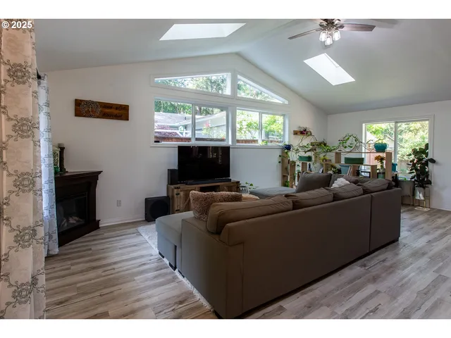a living room with furniture a large window and a flat screen tv