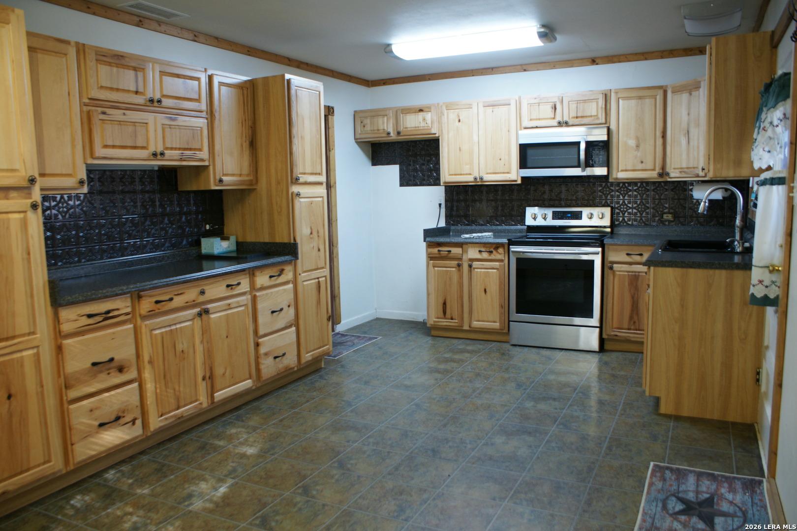 705 Altgelt Street Comfort, TX 78013 - Photo 10 of 14 a kitchen with stainless steel appliances granite countertop a stove a sink and a microwave
