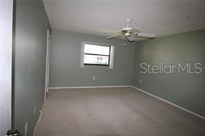 255 Mission Trail South, Unit J Venice, FL 34285 - Photo 5 of 15 an empty room with windows and fan