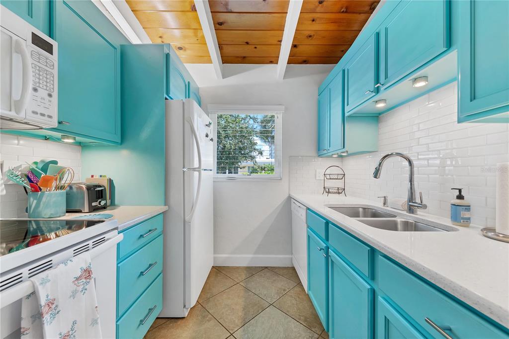 6006 Midnight Pass Road, Unit 16 Sarasota, FL 34242 - Photo 12 of 52 a kitchen with cabinets a sink and appliances