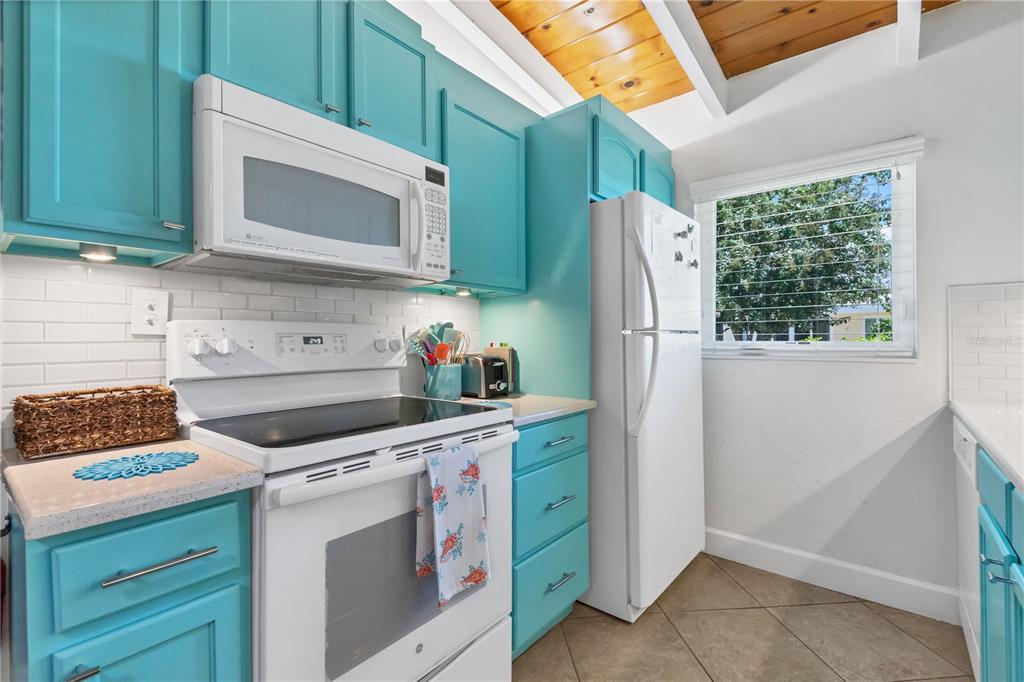6006 Midnight Pass Road, Unit 16 Sarasota, FL 34242 - Photo 13 of 52 a kitchen with stainless steel appliances white cabinets and a stove top oven