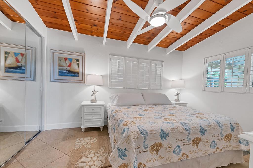 6006 Midnight Pass Road, Unit 16 Sarasota, FL 34242 - Photo 14 of 52 a bedroom with a bed and a painting on the wall