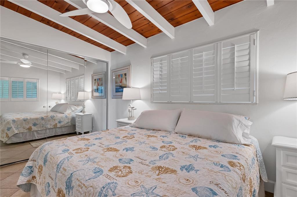 6006 Midnight Pass Road, Unit 16 Sarasota, FL 34242 - Photo 16 of 52 a bedroom with a large bed and a chandelier